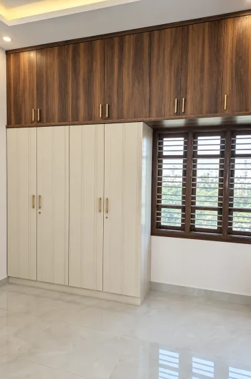 Bedroom wardrobe design at the Krishnamurthy residence in Makali, Bangalore, with cream doors and wood-finish loft storage above.