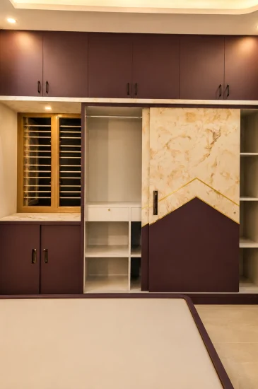 Completed bedroom wardrobe with overhead cabinets, open shelves and a decorative sliding panel at the Laxman project in Bengaluru.