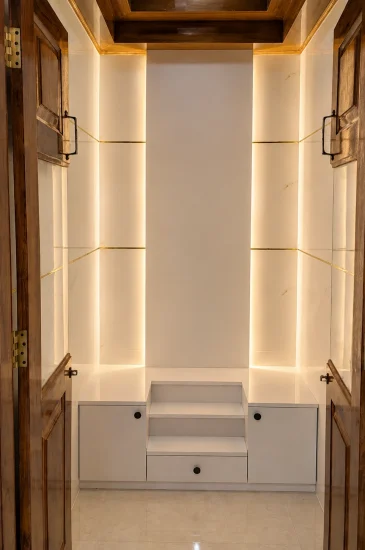 Completed pooja room interior design in Bengaluru for the Laxman project, with a stepped altar, storage drawers, wood framed doors and warm wall lighting.