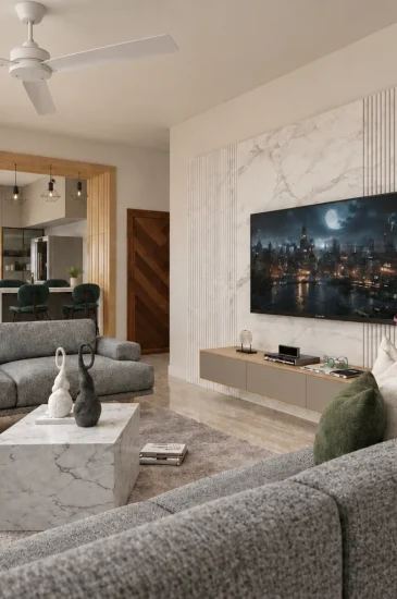 Living room TV unit design for the Manjunanth project, with a wall-mounted television, open display shelves and grey sofa seating