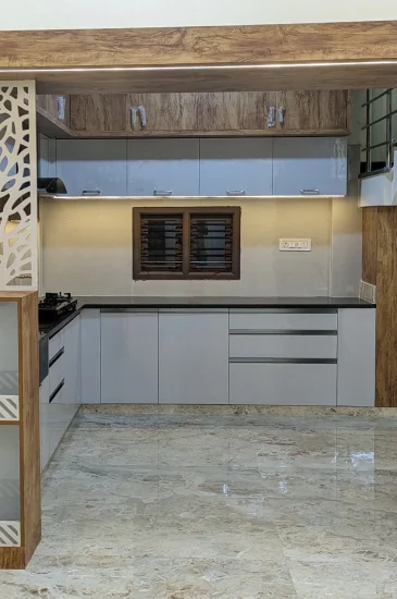 Living room TV unit design at the completed Palaksha Residency in Bagalgunte, Bangalore, with wood-finish framing, display shelves and a wall-mounted television