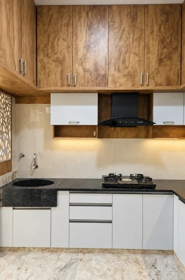Modular kitchen design at the completed Palaksha Residency in Bagalgunte, Bangalore, with wood-finish upper cabinets, light lower cabinets and a dark countertop